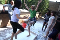 Middle school dance and try yoga stands in the water and corn starch mix without sinking into it outside of the GG Brown building on U-M North Campus.