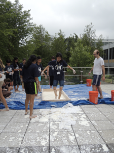 Campers watch as people run over the Oobleck pool one by one.