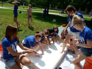 Students running their hands through a pool of Oobleck